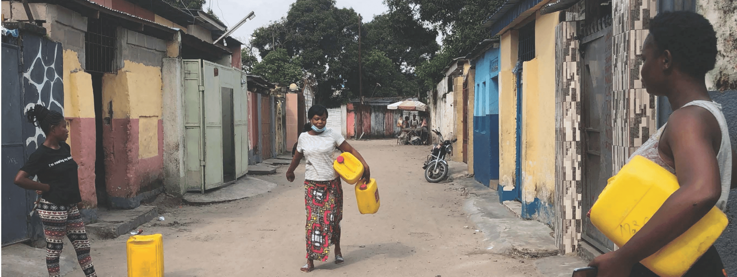 A Congolese woman carrying a large container down the road