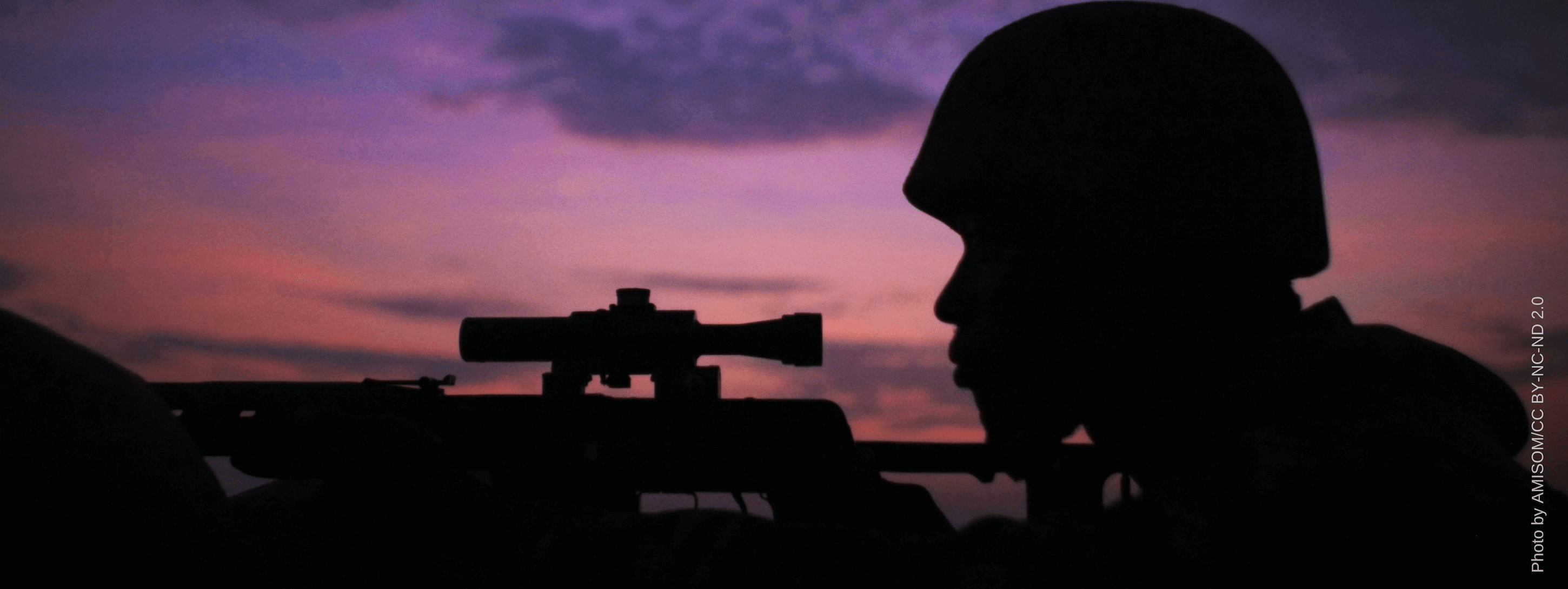 A soldier aiming a firearm
