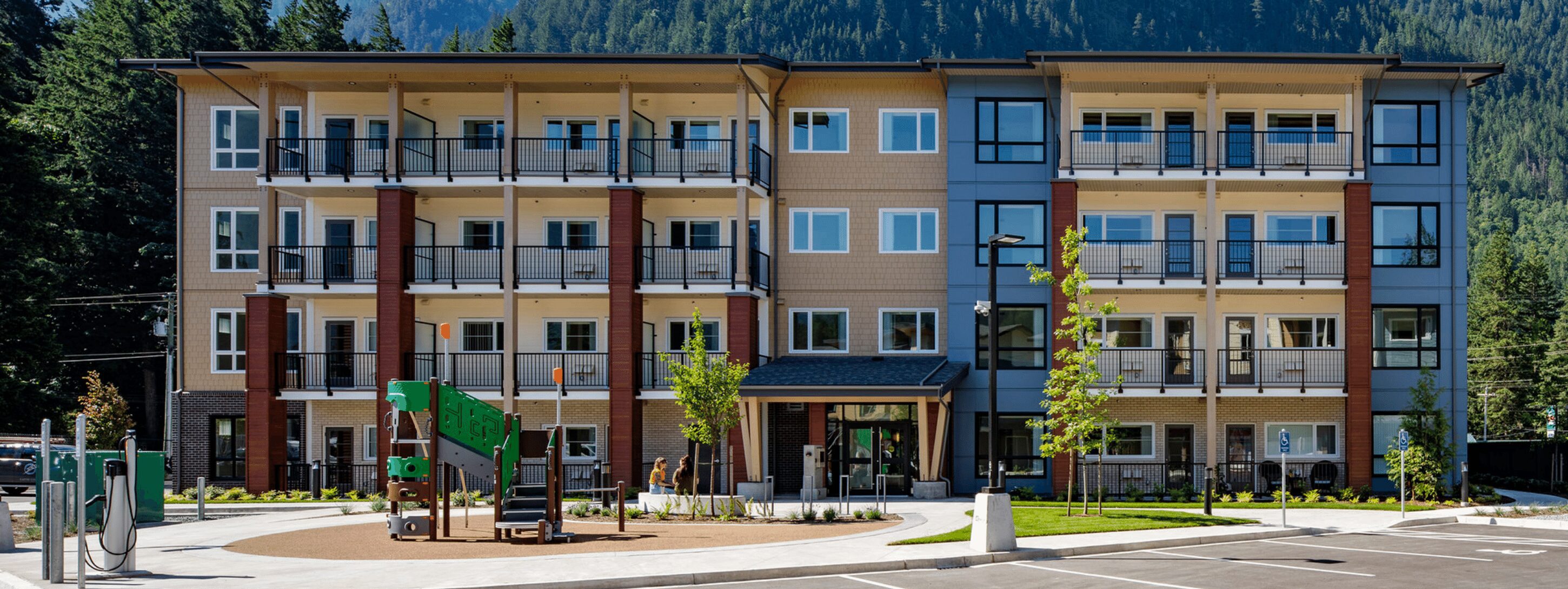 Modern apartment complex surrounded by forrest mountains