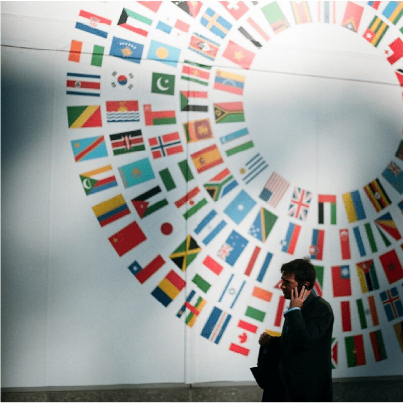 Man in front of wall painted with flags of all countries