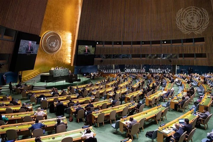 A photo of the United Nations General Assembly chamber with voting results displayed on screens. The results show a large number of votes against the resolution.