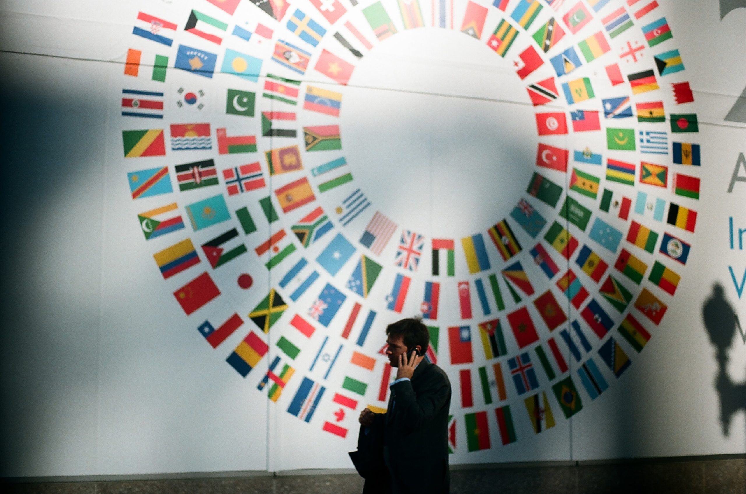 Man on cell phone in front of UN wall