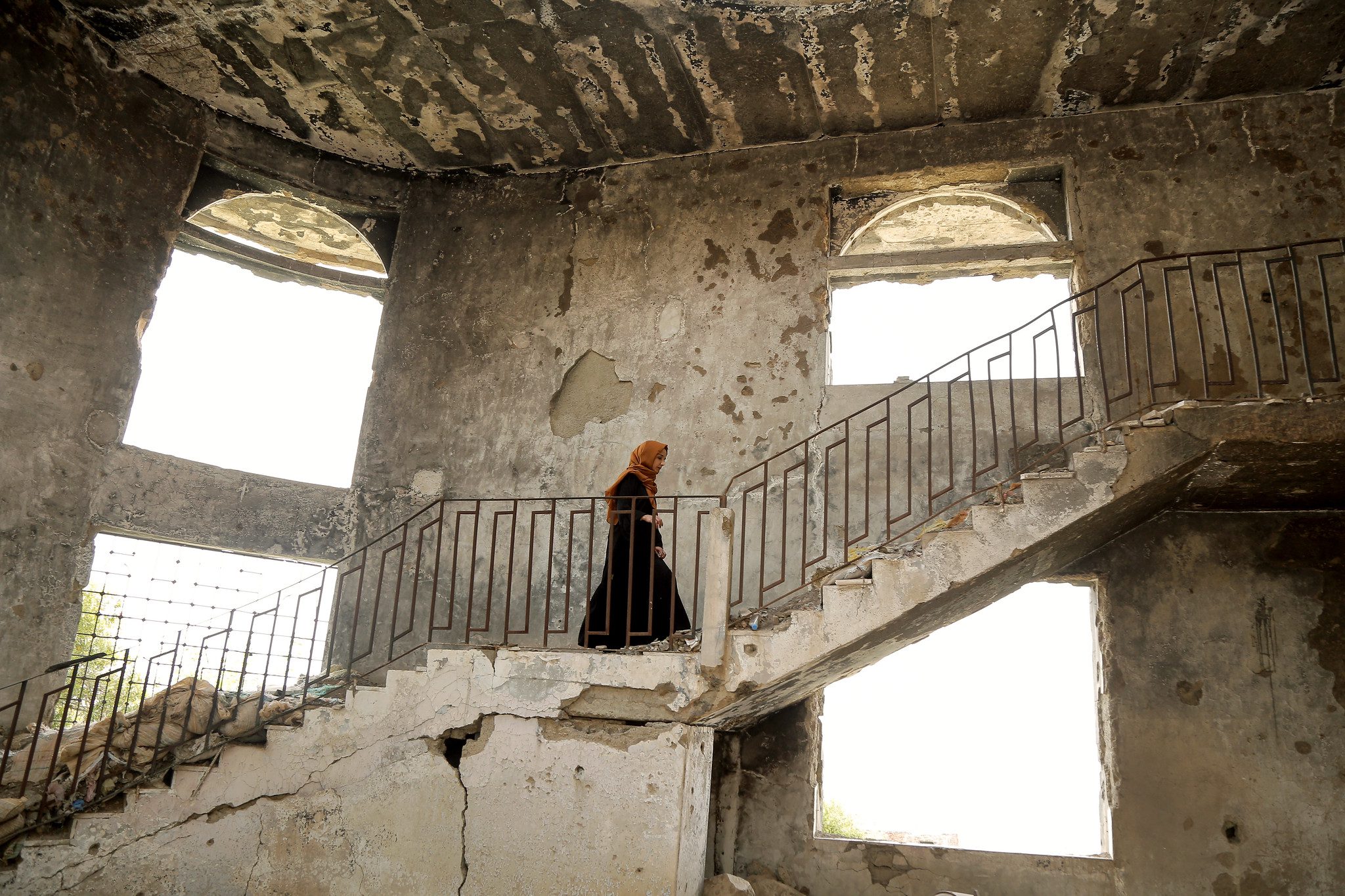 A woman climbing stairs in an old structure.