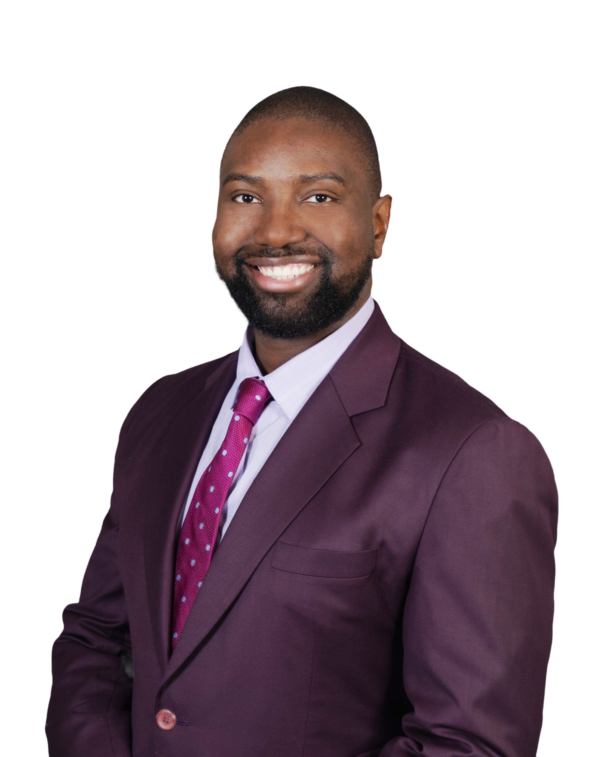 Headshot of a person wearing a purple suit and red tie with white background.