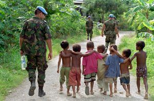 UN officer walking with third world children