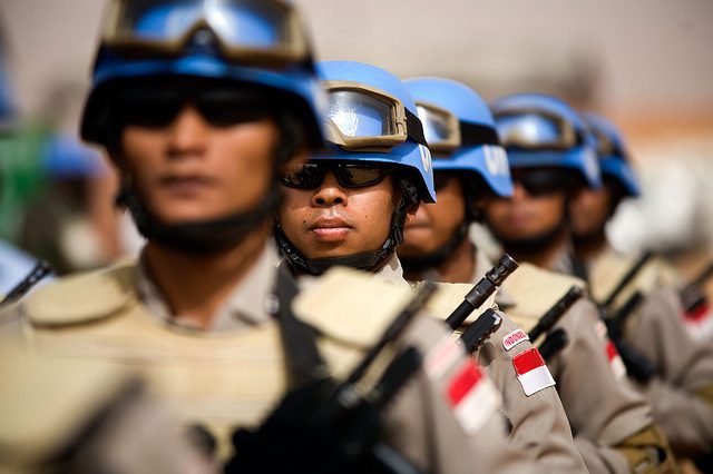 UN officers standing at attention with guns