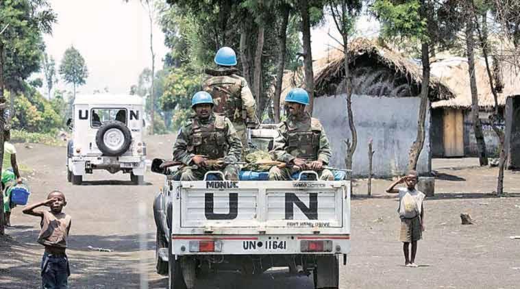 African children salute UN officers in a truck