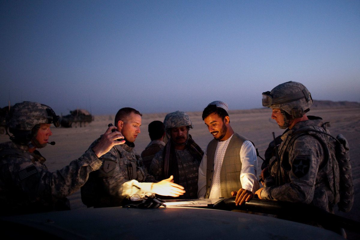 US troops reviewing a map with local Afghan man