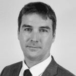 Black and white headshot of a person with short hair in a suit.