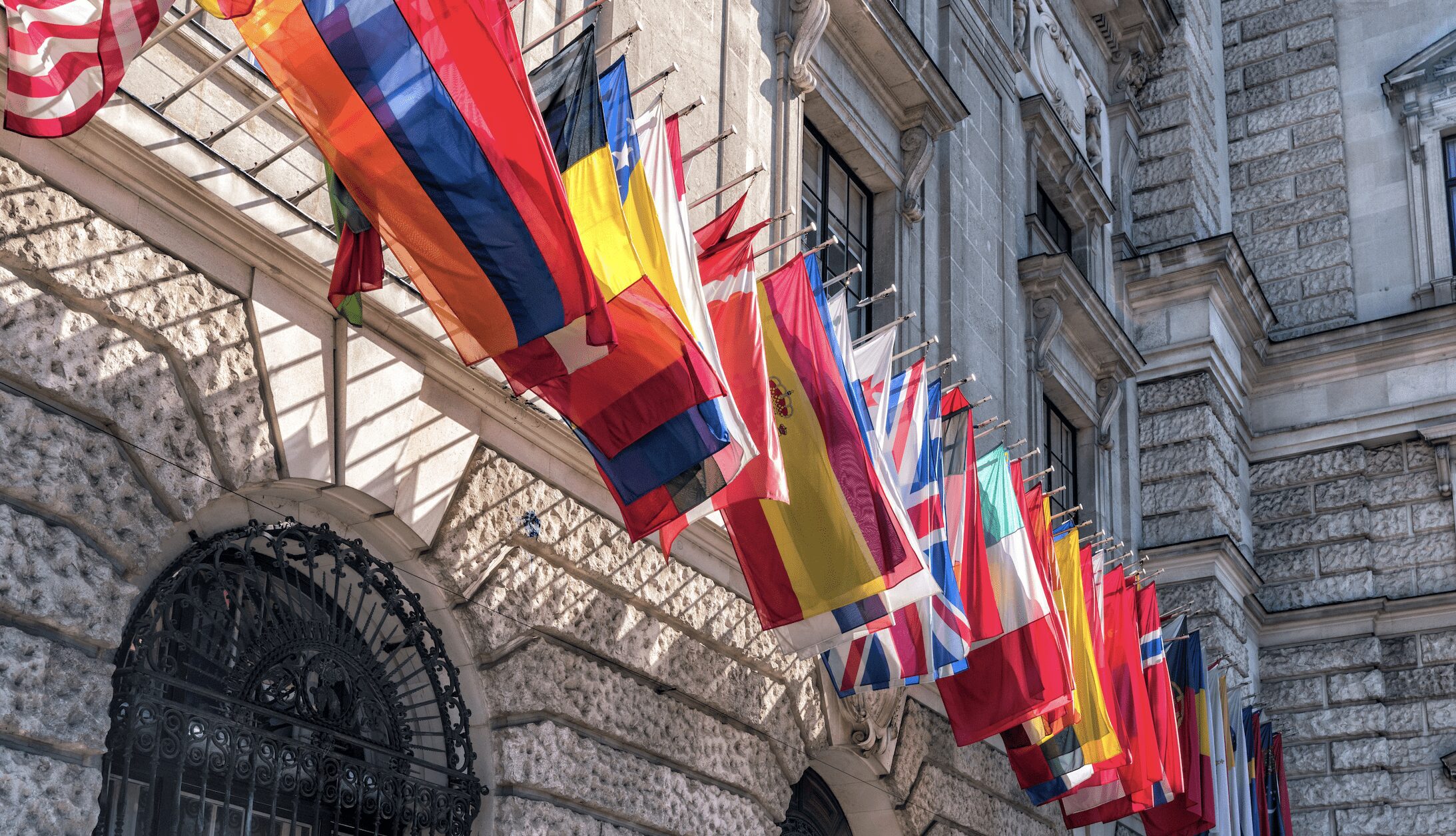 Row of flags hanging from stone building