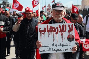 A Tunisian protester in March 2015 carrying a poster speaks that says 