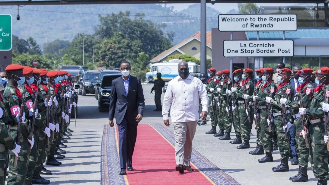 Two people walking down a runway between two lines of soliders.