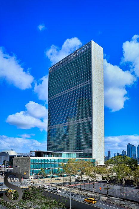 United Nations HQ in New York against a cloudy blue sky.