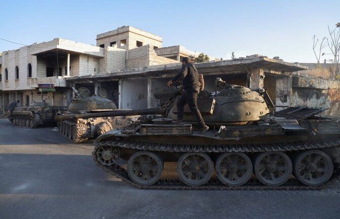 Syrian opposition fighters maneuver using armored vehicles seized from the Syrian army in the town of Maarat Al-Numan, south of Idlib, Syria.