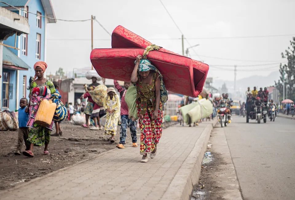 A woman with belongings flees from Kibati, where fighting has intensified, on Jan. 26.