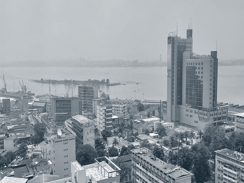 Black and white photo of buildings against a harbor in Kinshasha, Democratic Republic of Congo.