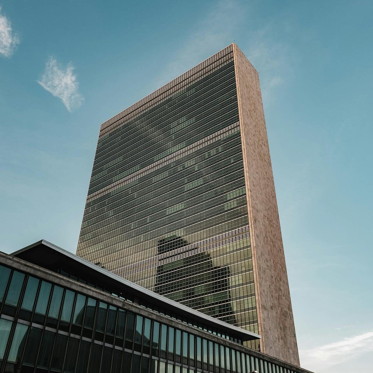 Close-up photo of the United nations building in New York with the blue sky in the background.