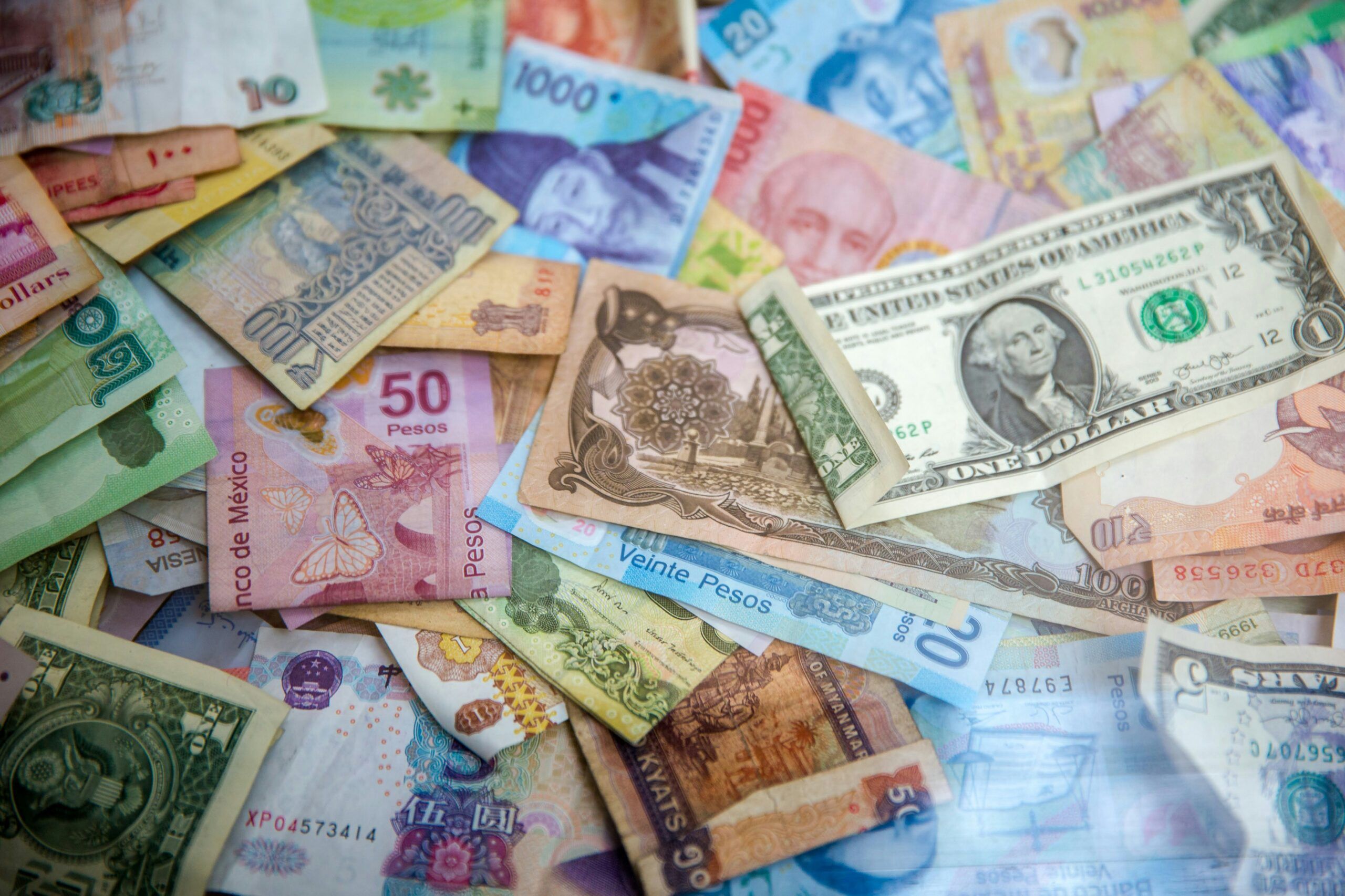 Different currency bills scattered across a flat lay.