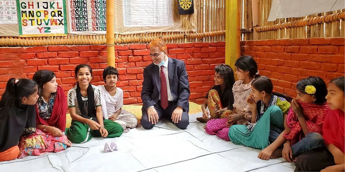 Photo of Justice Imman Ali, Supreme Court of Bangladesh, in the middle of a group of children.