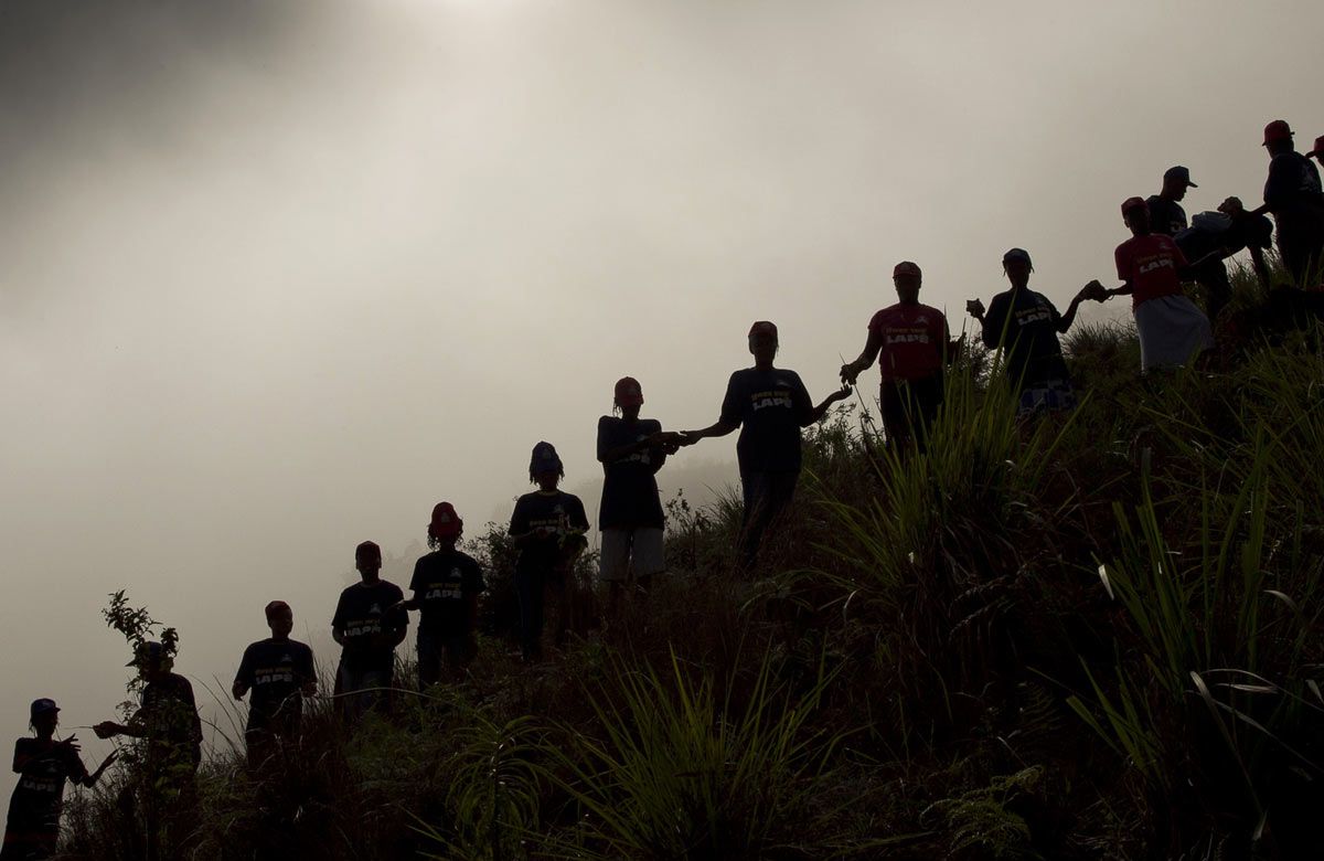 silhouette of people in an assembly line on a hill