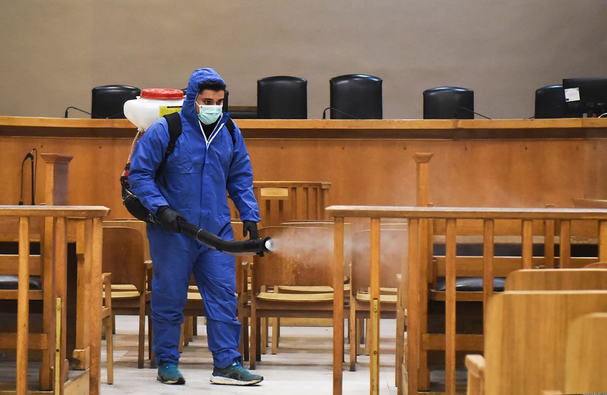 man in hazmat steam cleaning UN meeting room