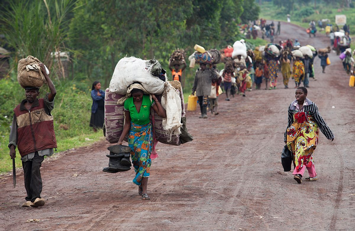 dozens of african american refugees walking on dirt road