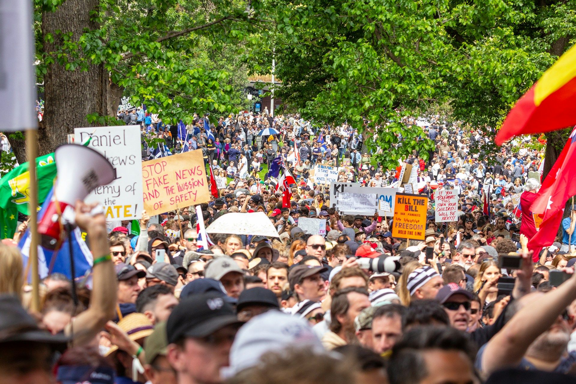 Large crowd of people holding up protest signage in Melbourne, Australia