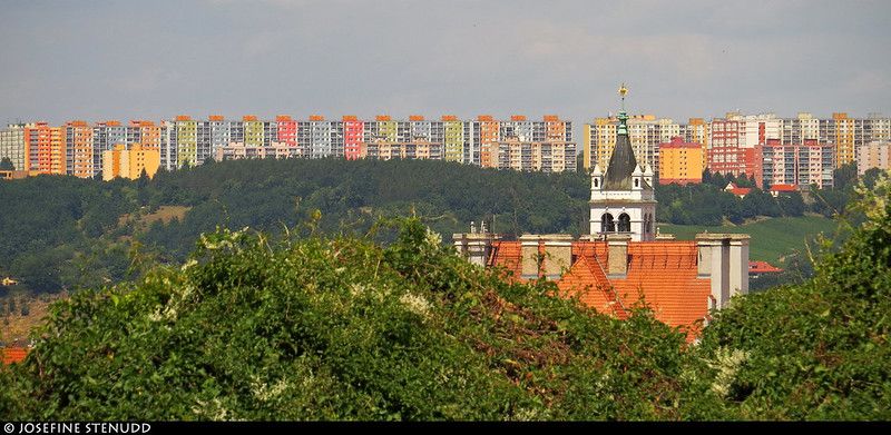 Church & distant colourful apartment buildings in Prague, the Czech Republic