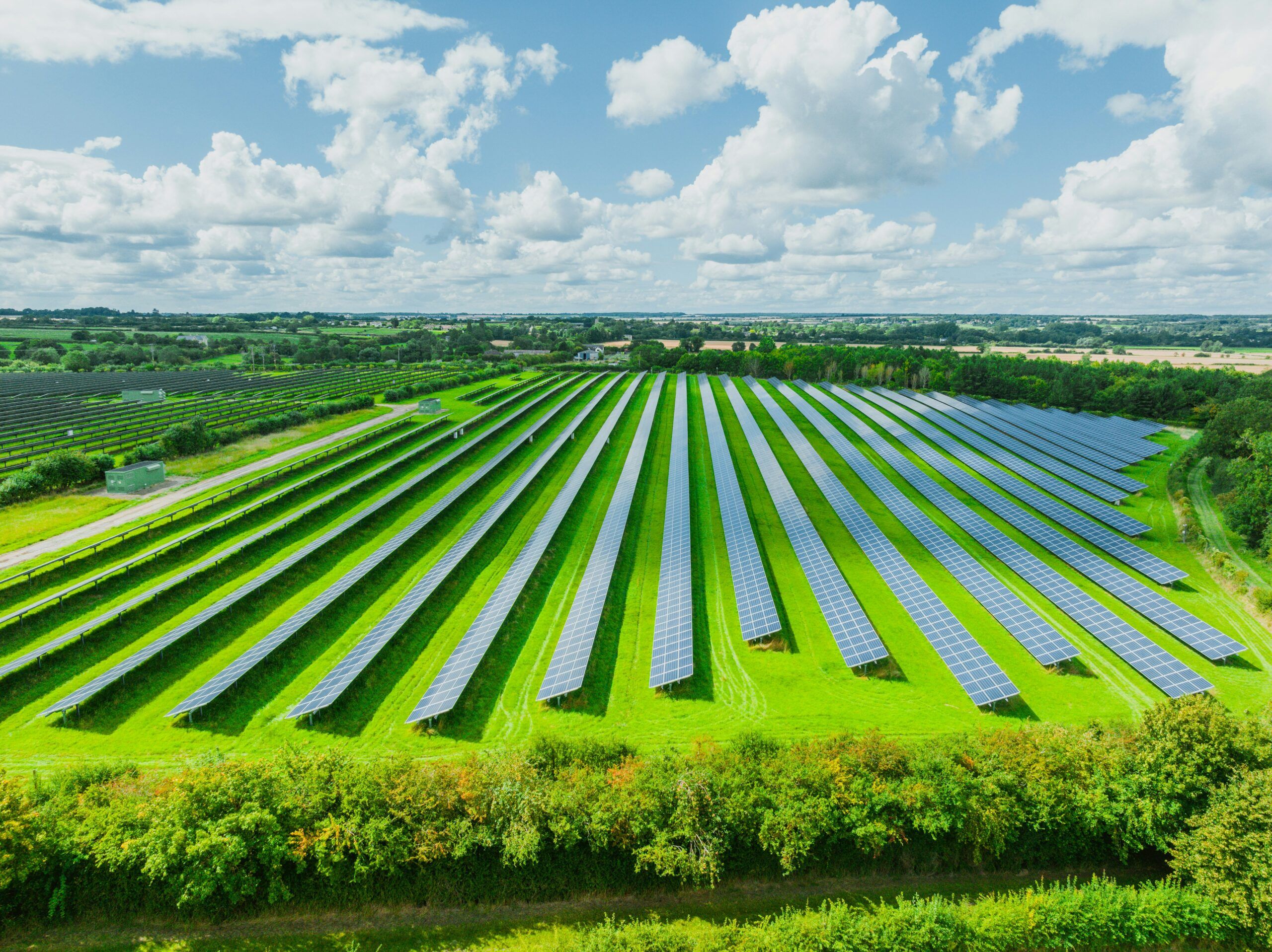 Photo of a solar farm with clouds in the background.
