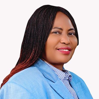 Headshot of a person's side profile wearing a light blue blazer with long brown hair.