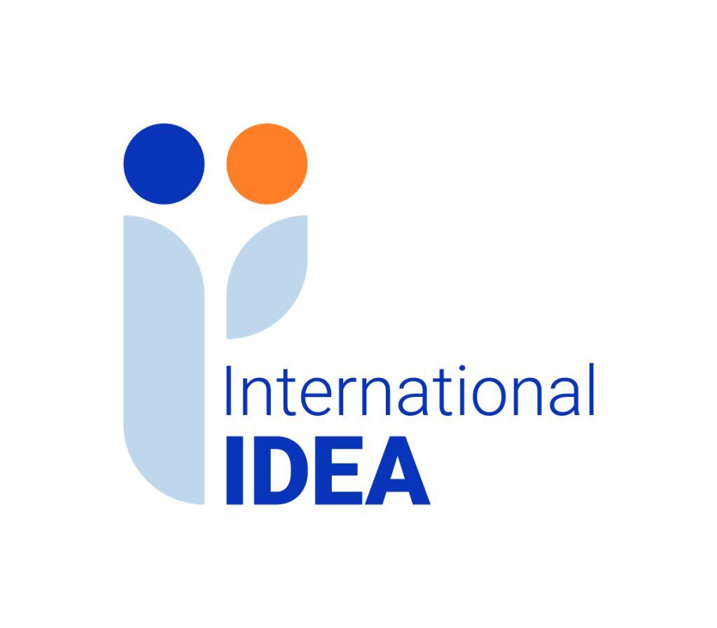 Text: International IDEA. Below two blue and orange circles over a tree branch
