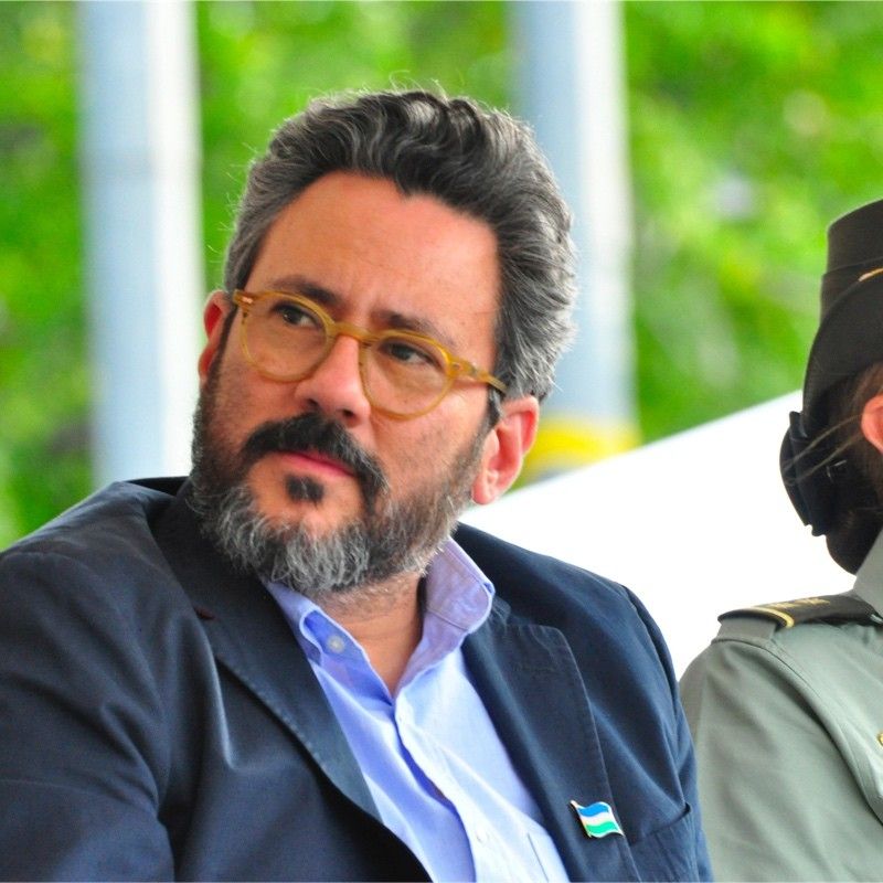 Close-up of a person wearing glasses with short hair, their head tilted to the side.