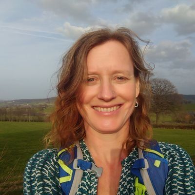 Headshot of a smiling person outdoors.