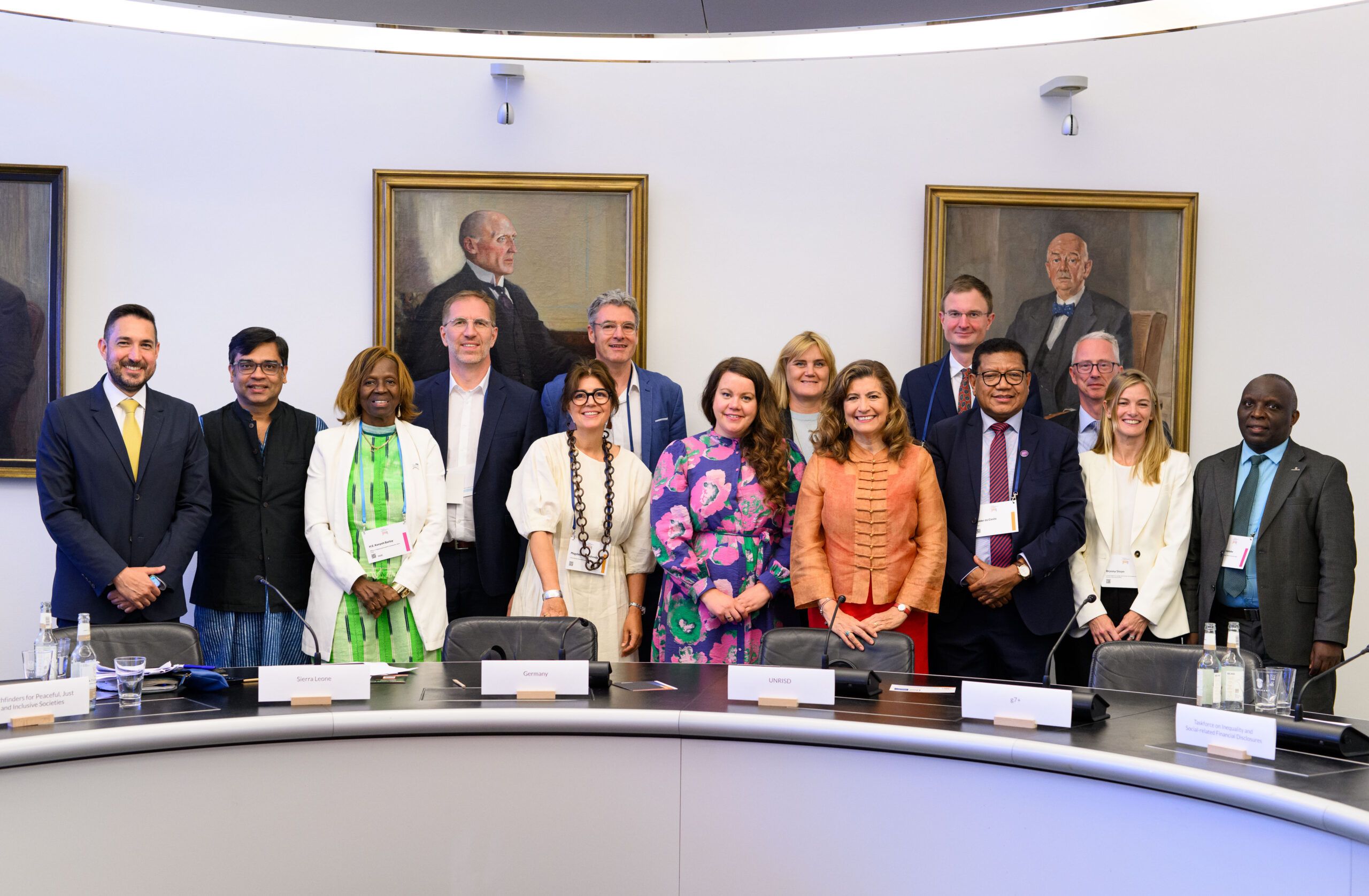 Group photo of the members of the Global Alliance Against Inequality in front of a round table.